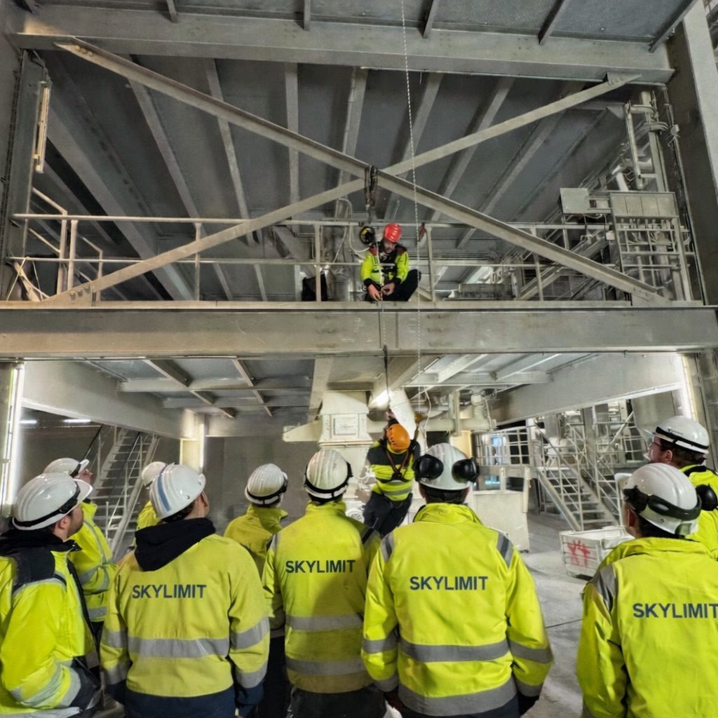 Kletterausrüstung Ausrüstung Kletterausrüstung Seile Karabiner Prüfung DGUV Gelbe Rucksäcke mit Sicherheitsausrüstung und Seilen in einem Outdoor-Umfeld.