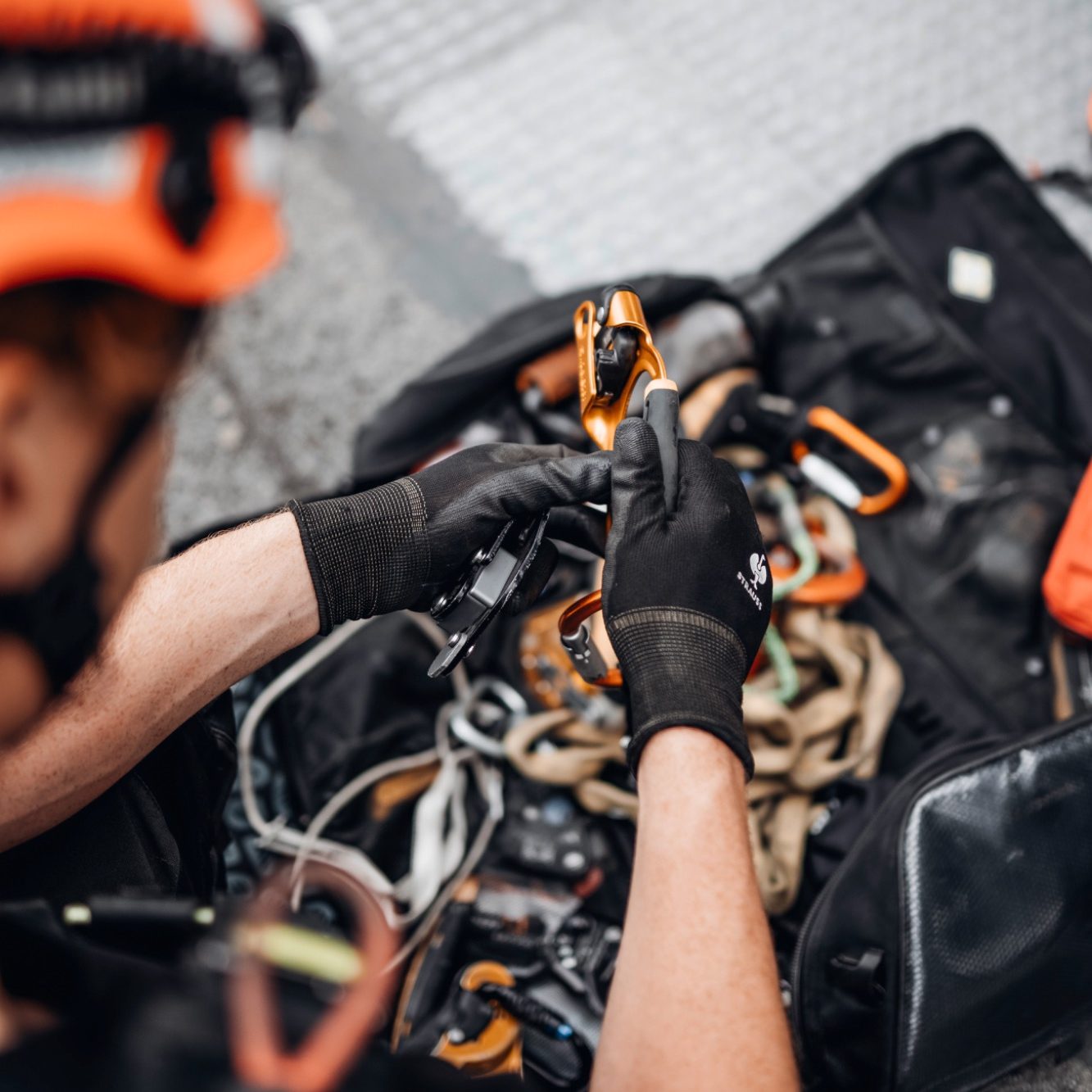 Kletterausrüstung Ausrüstung Kletterausrüstung Seile Karabiner Prüfung DGUV Gelbe Rucksäcke mit Sicherheitsausrüstung und Seilen in einem Outdoor-Umfeld.